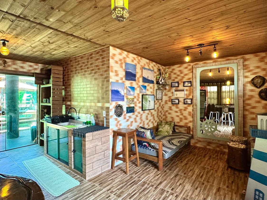 Copa com cozinha compartilhada e parede de quadros de surfe
